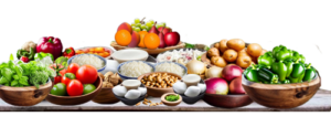 rustic table with bowls of fresh vegetables, fruits, small pies, and nuts. 
